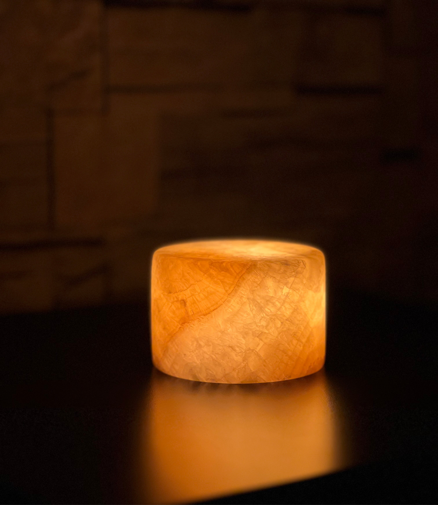 Dekorativ mörk marmorlampa med trådlös funktion och varm belysning, placerad på soffbord i harmonisk inredningsstil.