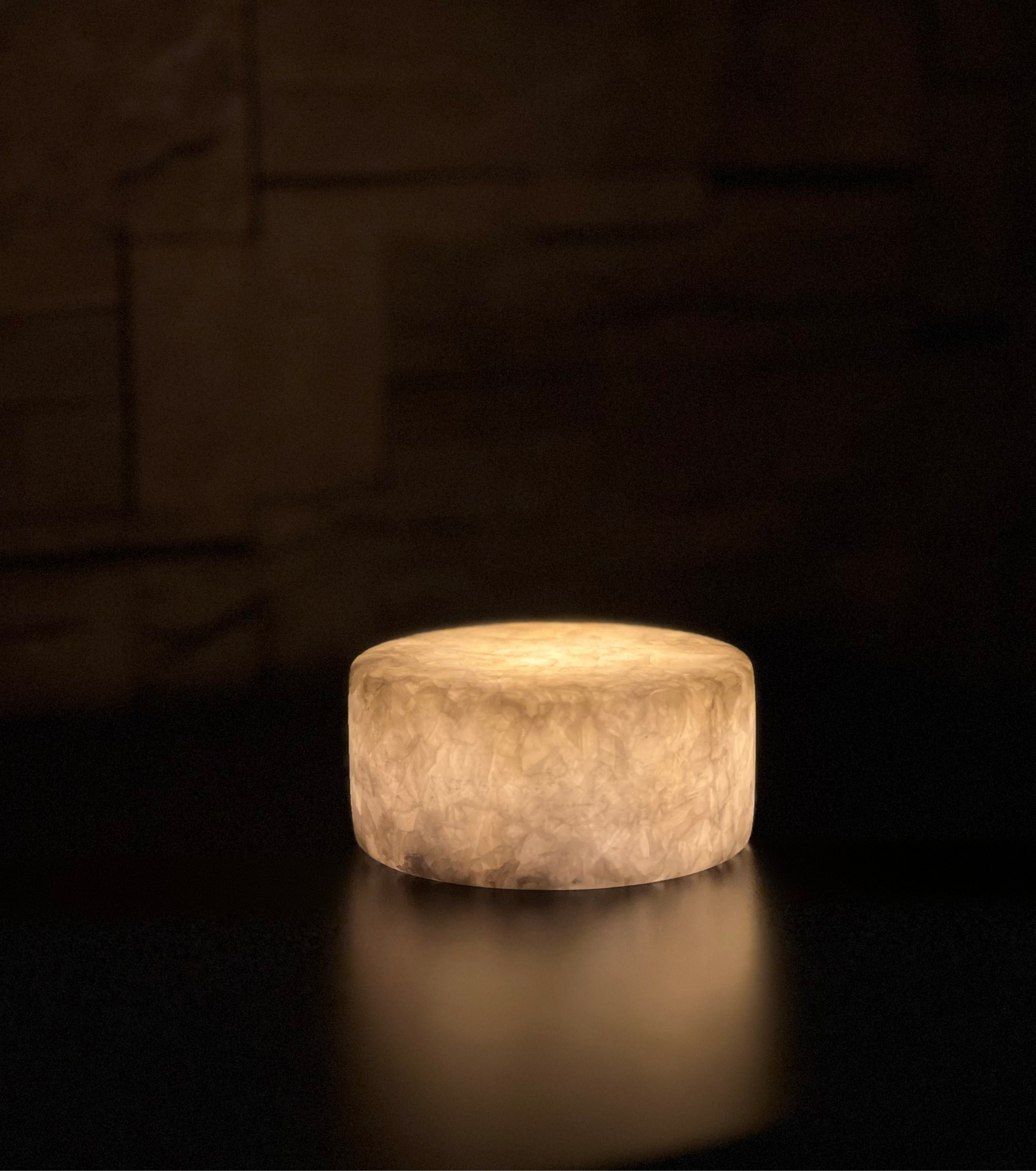 Batteridriven bordslampa i äkta vit marmor med varm mysbelysning och timerfunktion, placerad på stilrent sidobord.