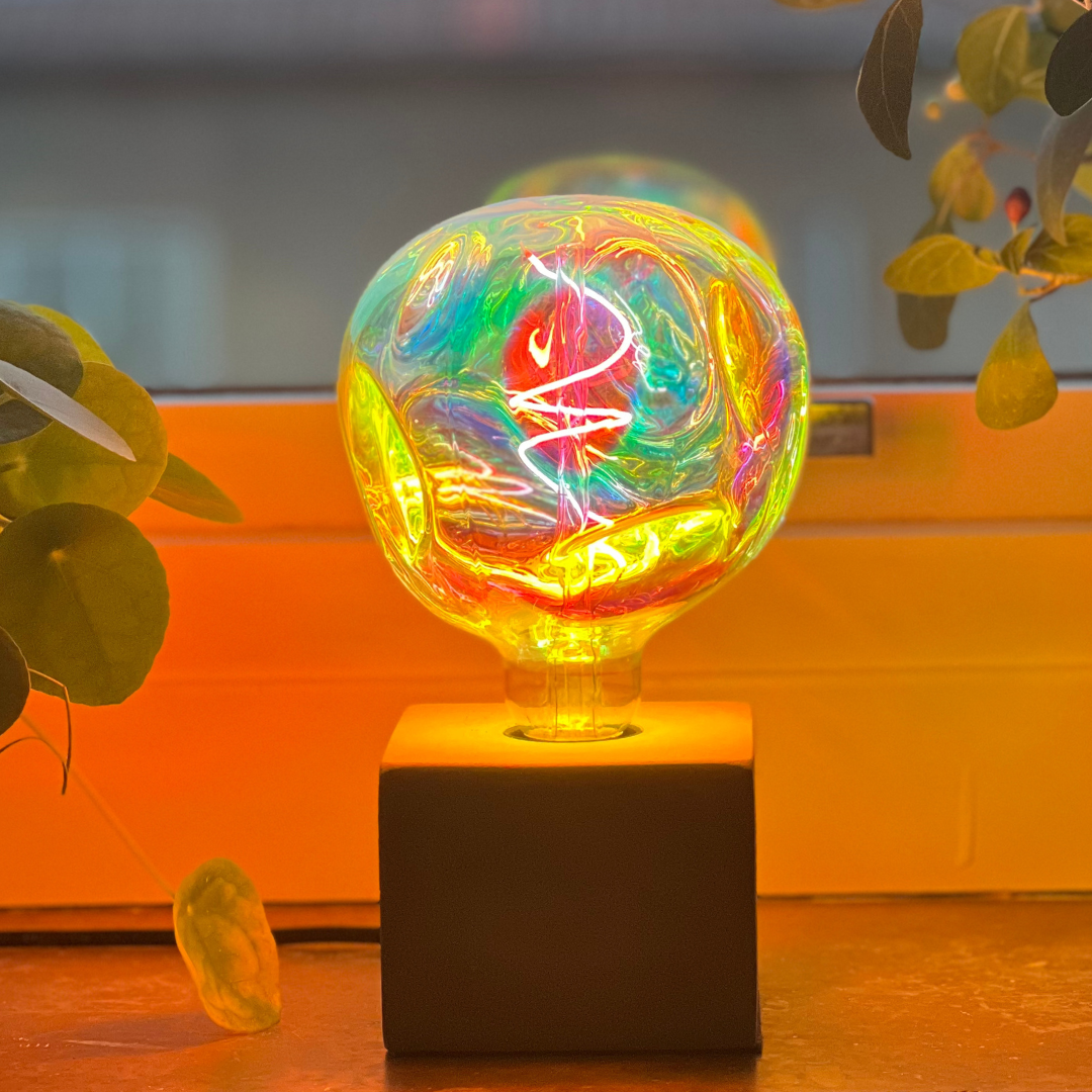 LED-lampa med regnbågseffekt som accentbelysning i vardagsrum. Detaljbild av Regnbågslampa med unikt ljusspel i flera färger.