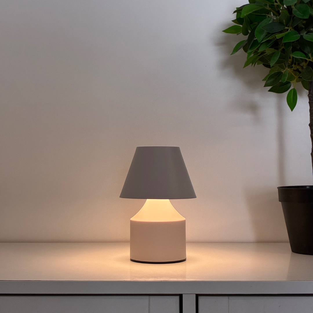 Beige bordslampa i form av kruka med varm LED-belysning, perfekt som stämningsljus på soffbord eller fönsterbänk.