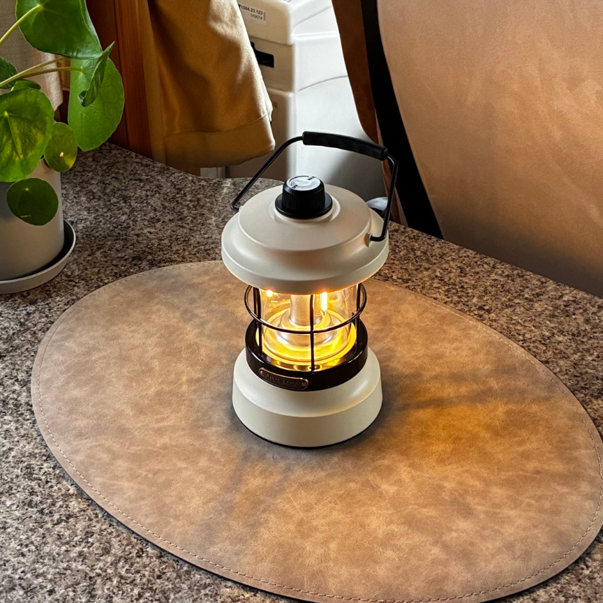Retro campinglampa med uppladdningsbar LED placerad på bord i husvagn eller campingmiljö